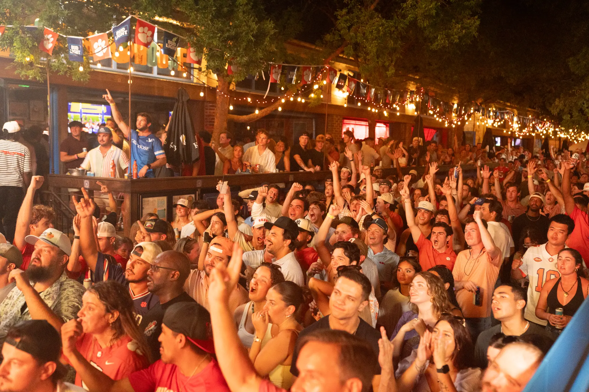 A crowd cheering outside Share House during a Camden Alley football watch party