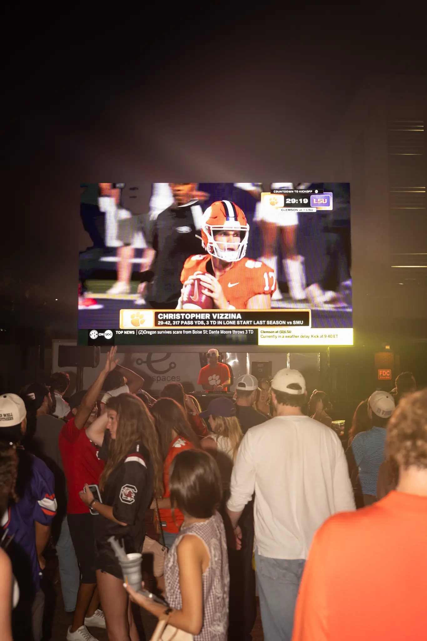 Guests watching college football on the outdoor screen at a Camden Alley watch party