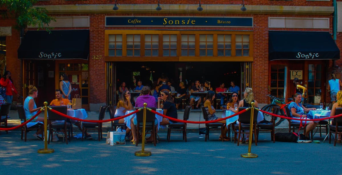 a group of people sitting at a table in front of a building