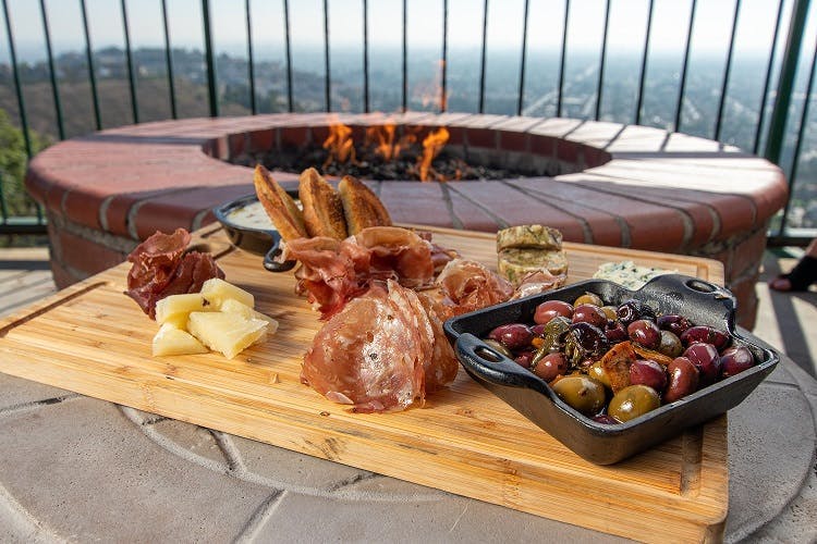 a charcuterie board by a fire pit