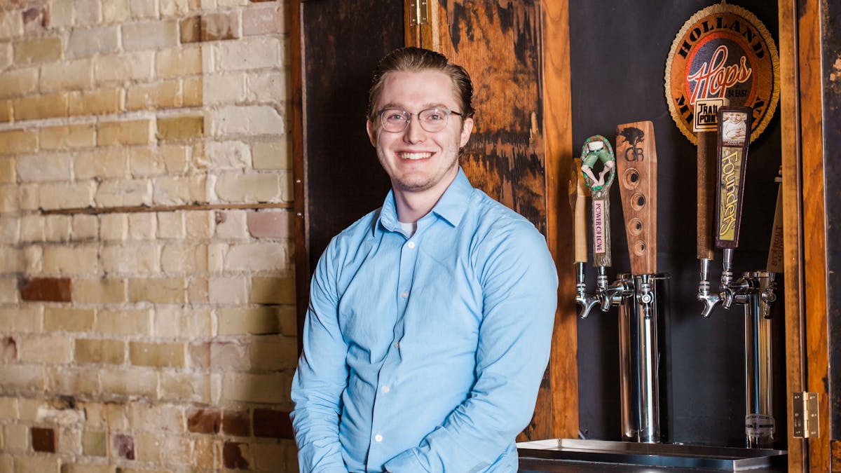 a person standing in front of a brick wall posing for the camera