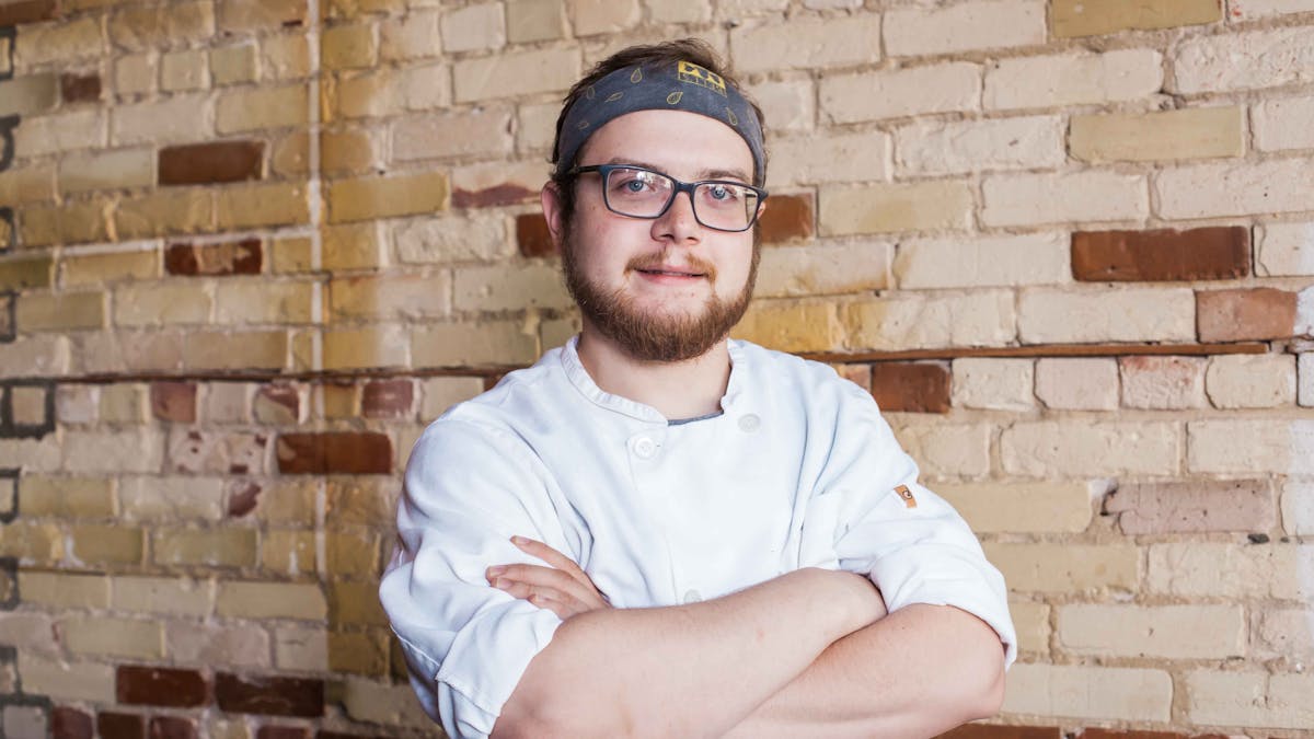 a man sitting in front of a brick building