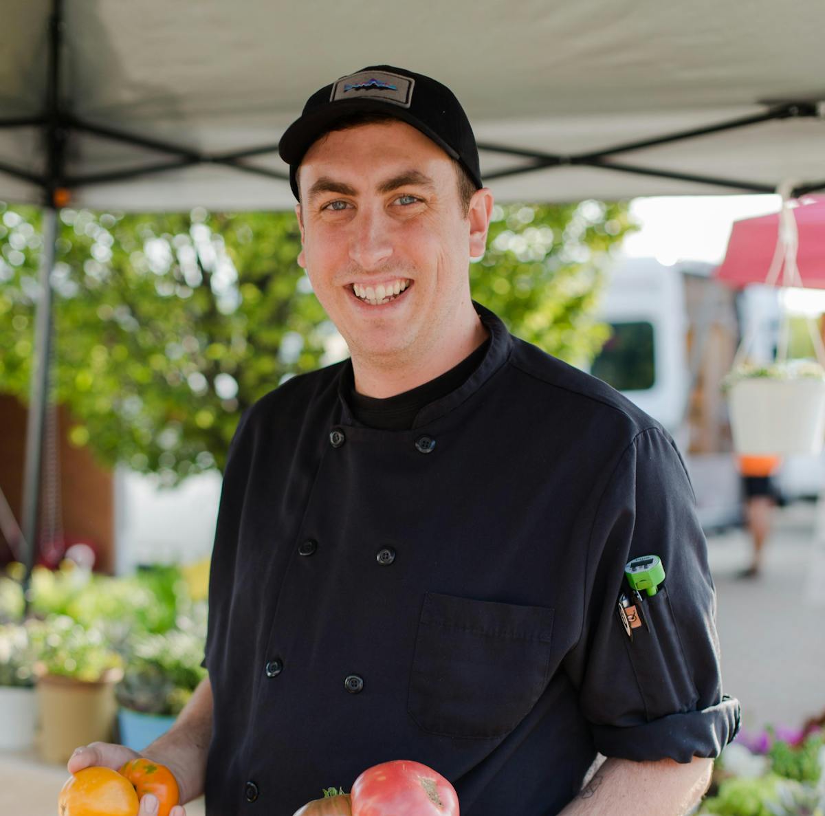 a man standing in front of a fruit stand
