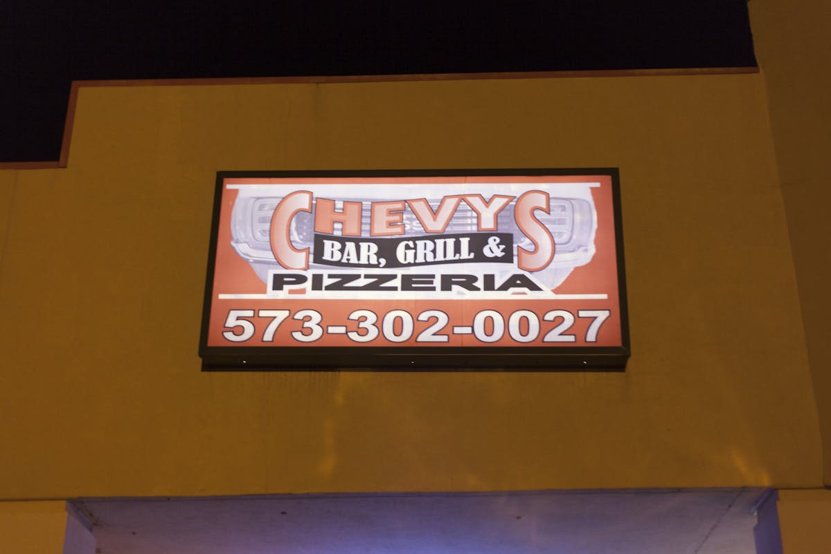 a yellow sign hanging on a wall
