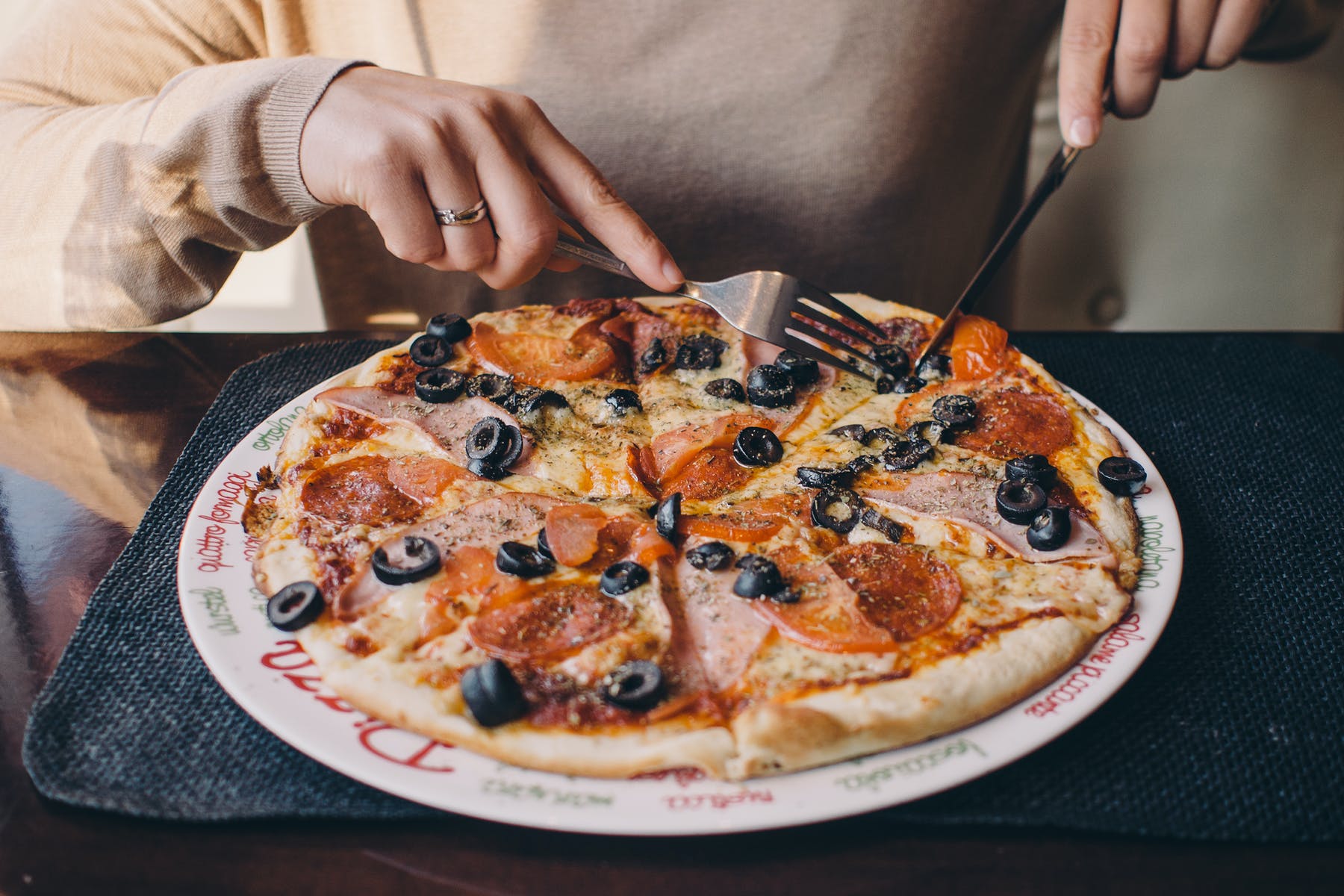 a person holding a plate of pizza