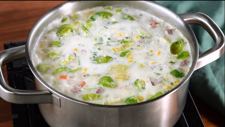 a bowl of soup on a metal pan on a stove