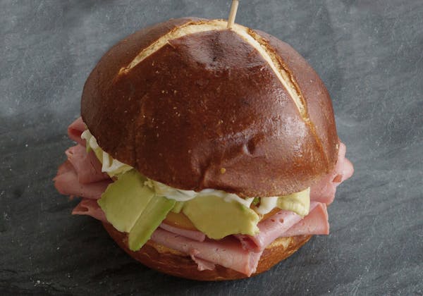 a half eaten sandwich sitting on top of a piece of paper