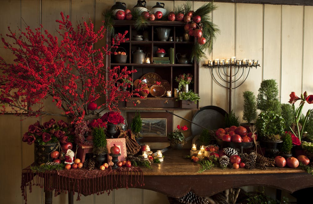 a vase of flowers on a table next to a christmas tree