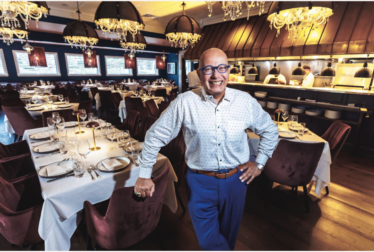 a man standing in front of a restaurant
