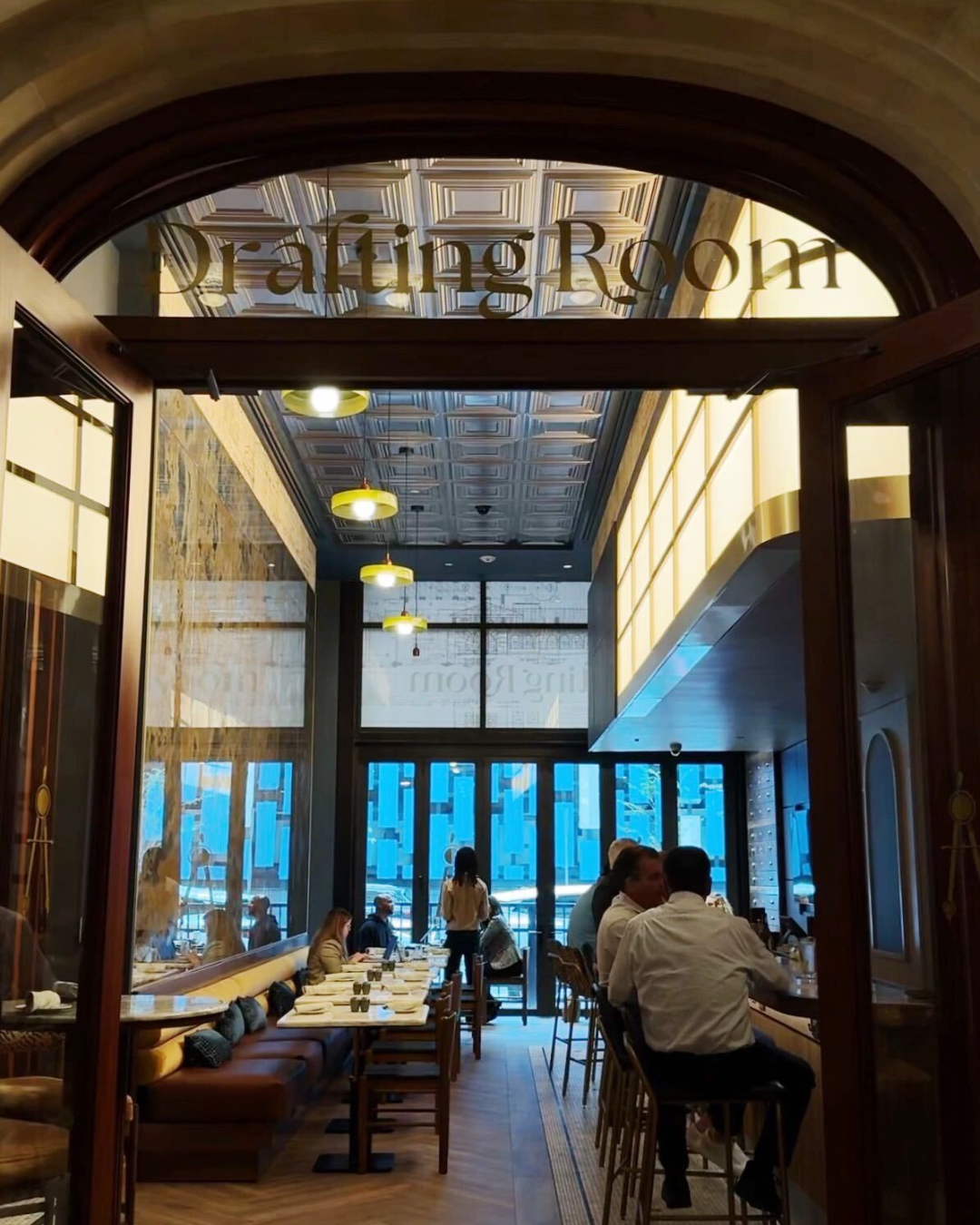 a group of people sitting at tables in a restaurant