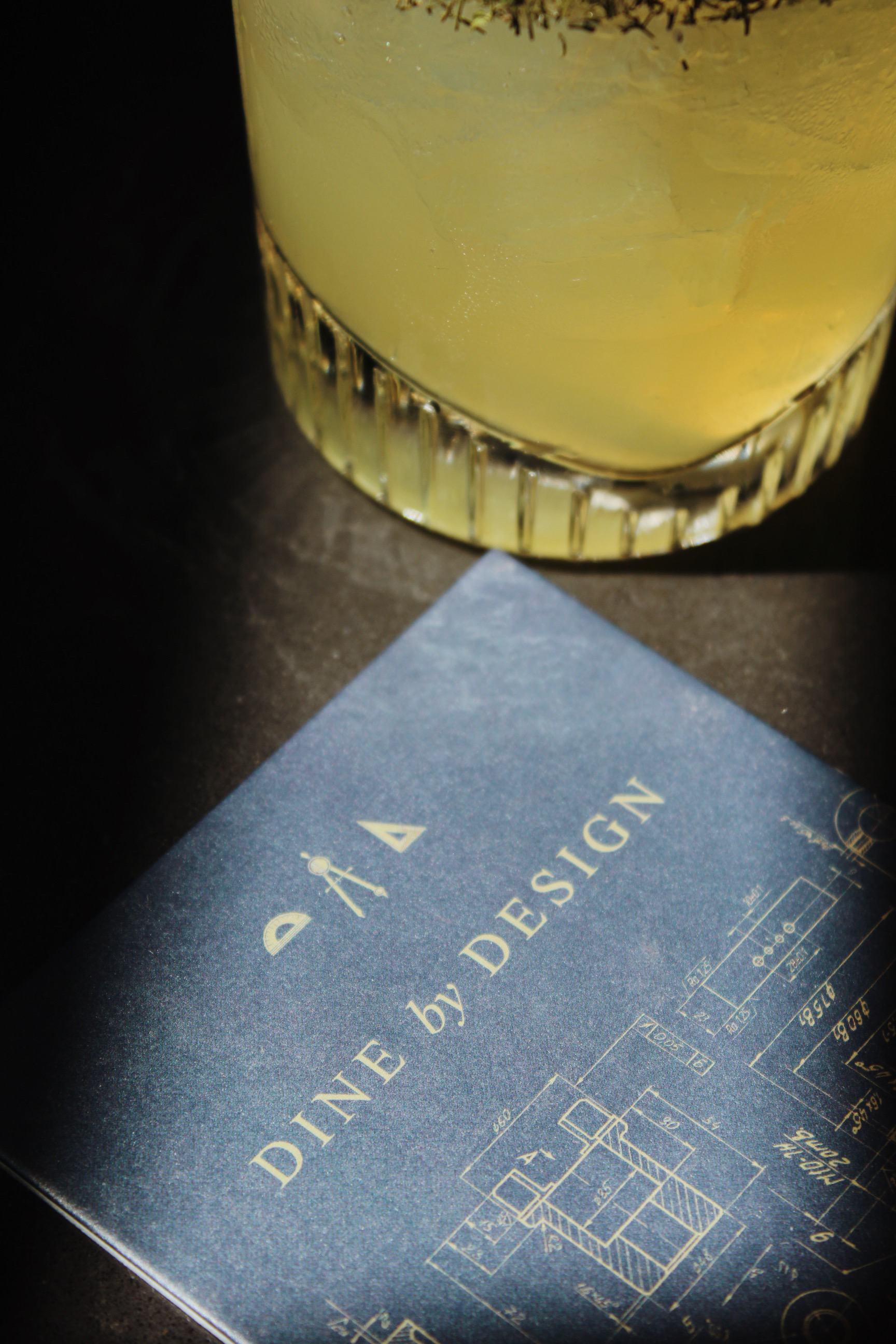a glass of liquid next to a blue book