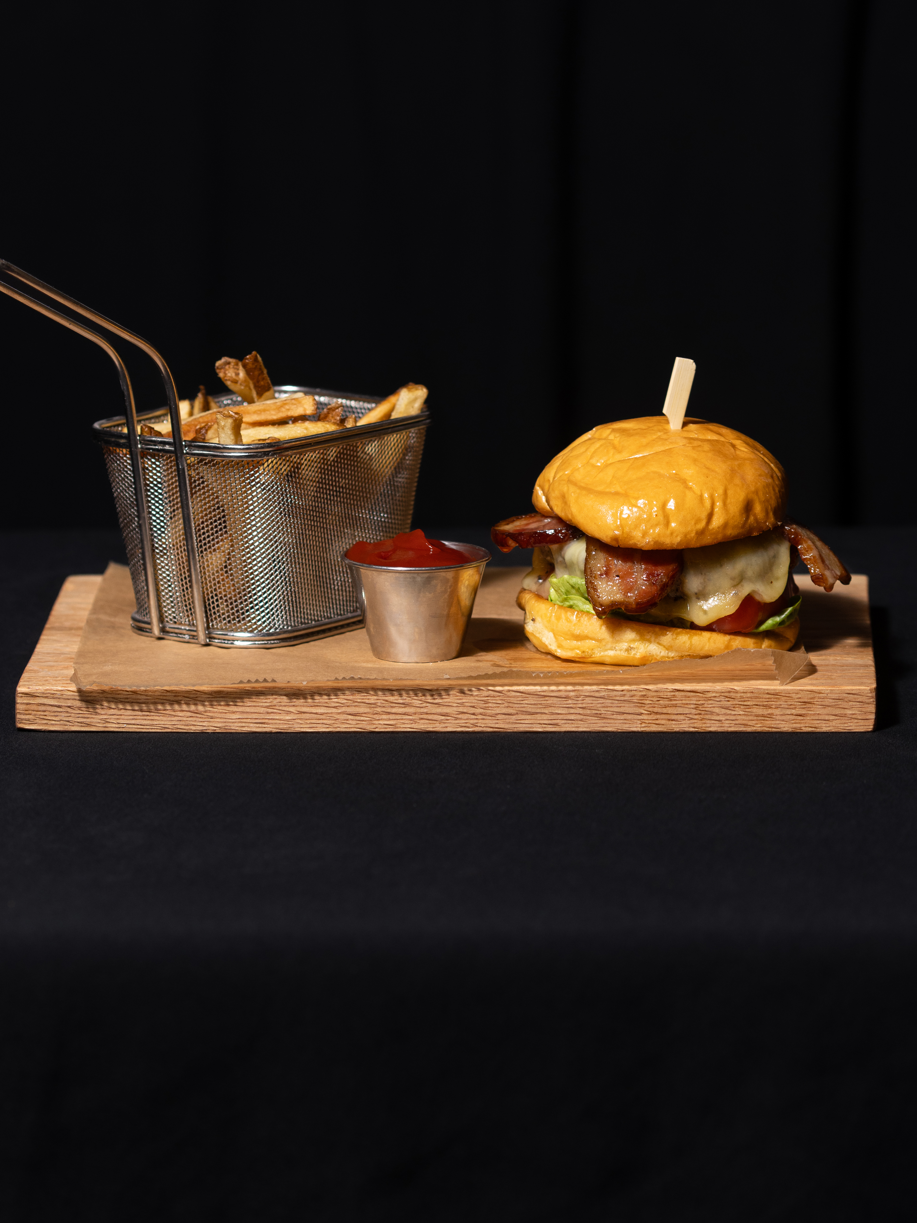 a burger and fries on a wooden tray