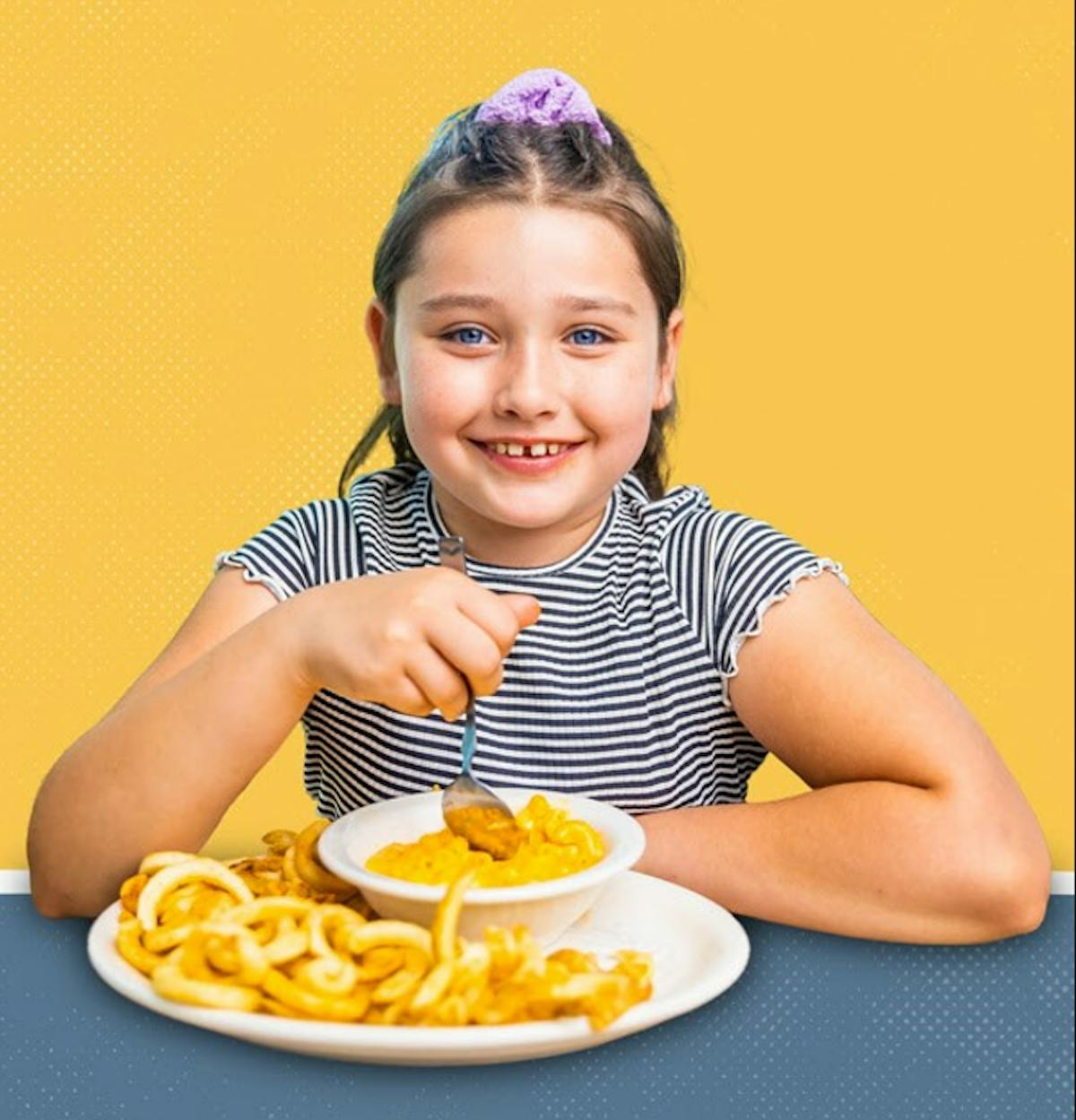 a woman sitting at a table with a plate of food