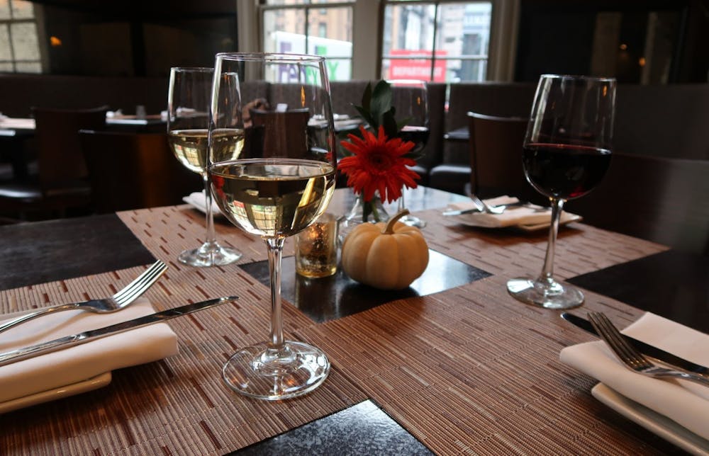 a glass of wine sitting on top of a wooden table