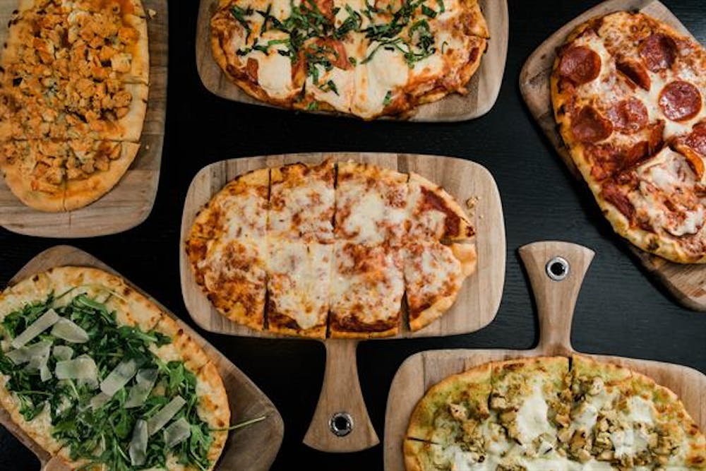 a pizza sitting on top of a wooden table