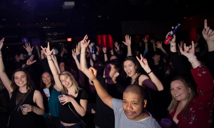 a group of people standing in front of a crowd posing for the camera