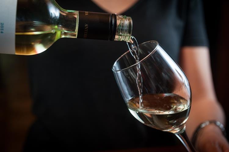 a close up of a person holding a wine glass