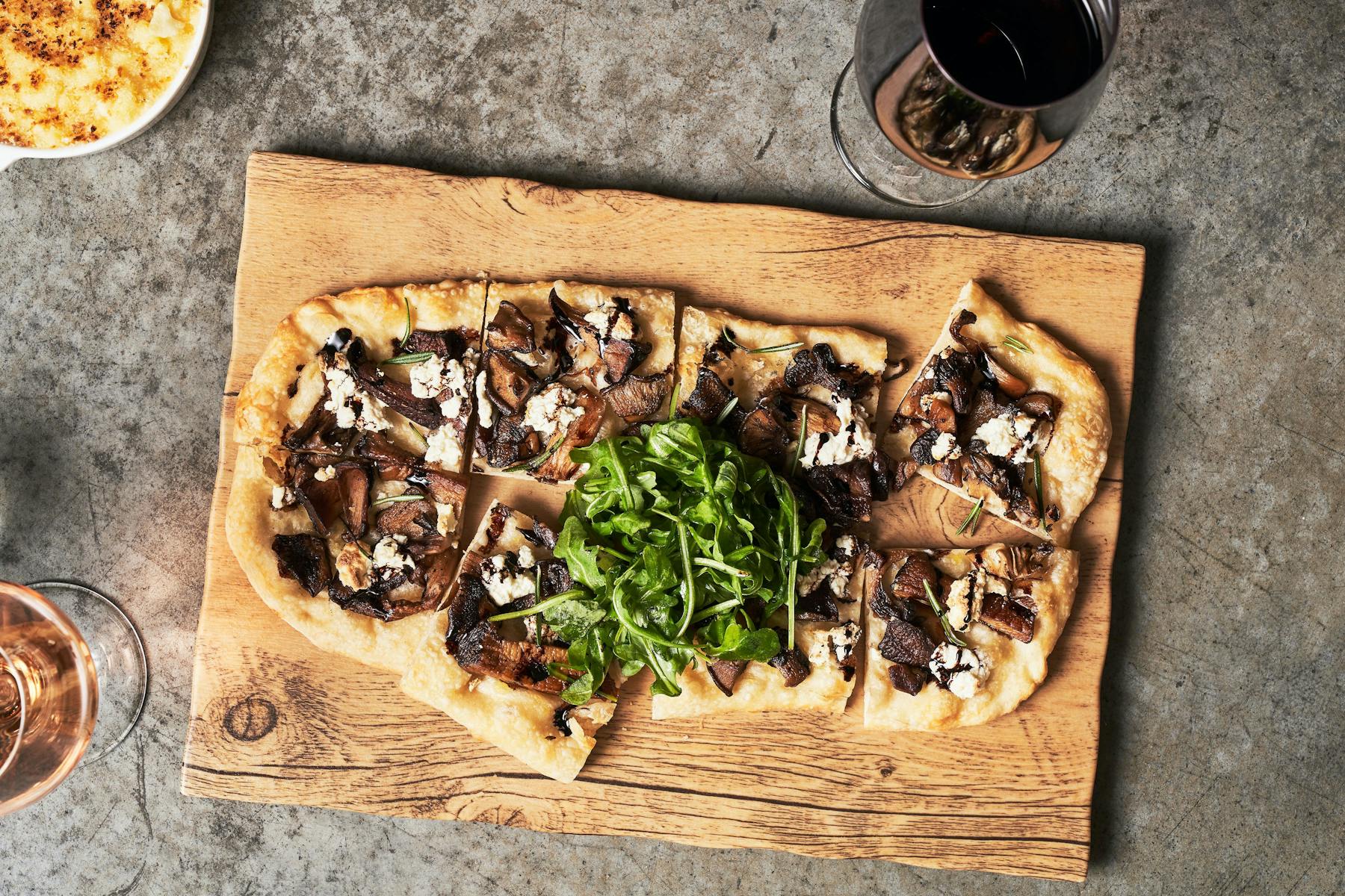 a pizza sitting on top of a wooden cutting board