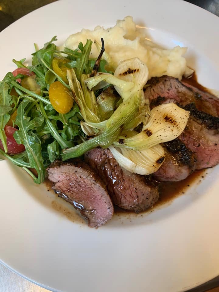 a white plate topped with meat and vegetables