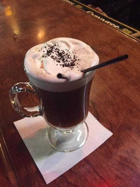 a cup of coffee sitting on top of a wooden table