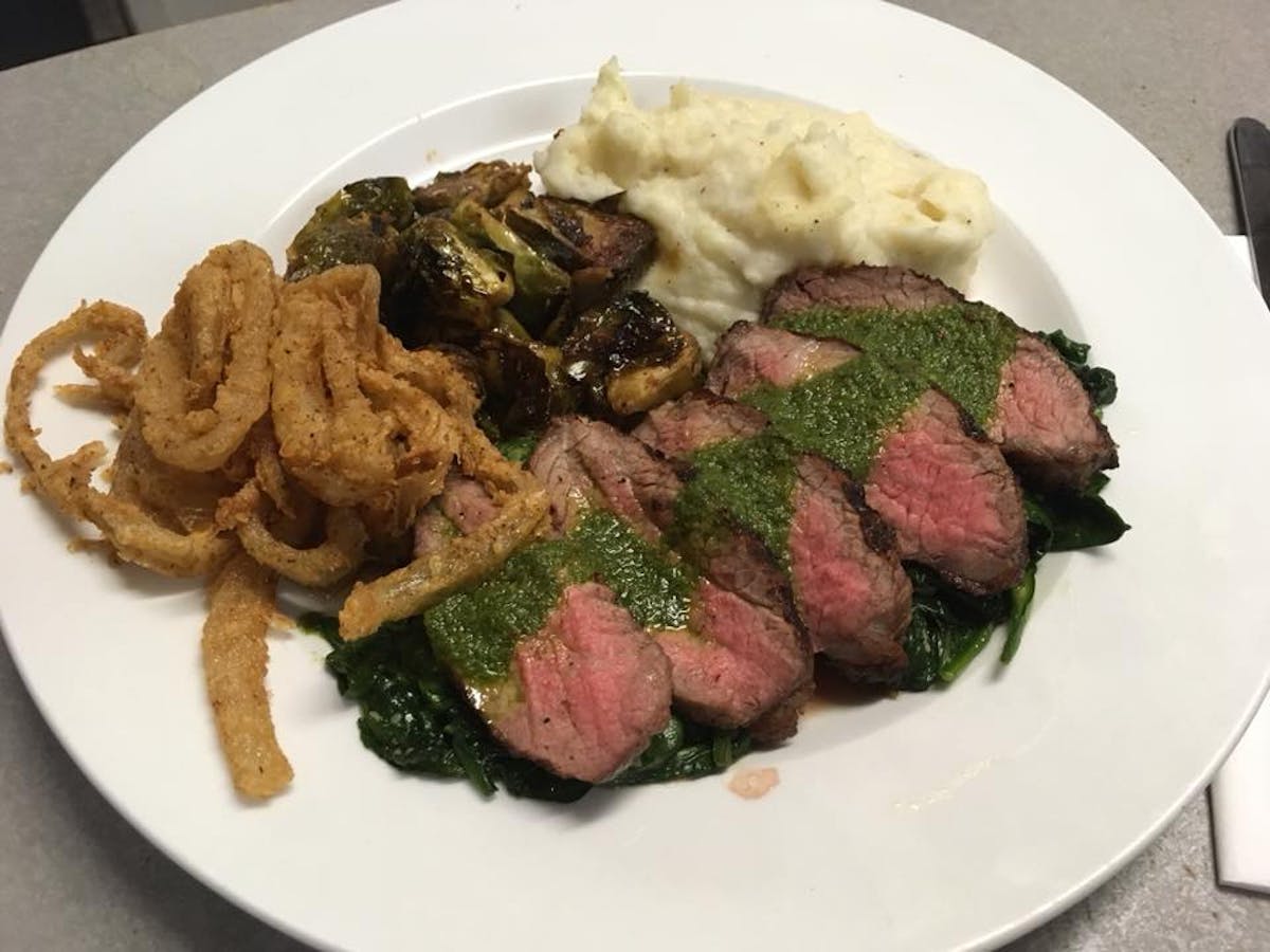a white plate topped with meat and vegetables