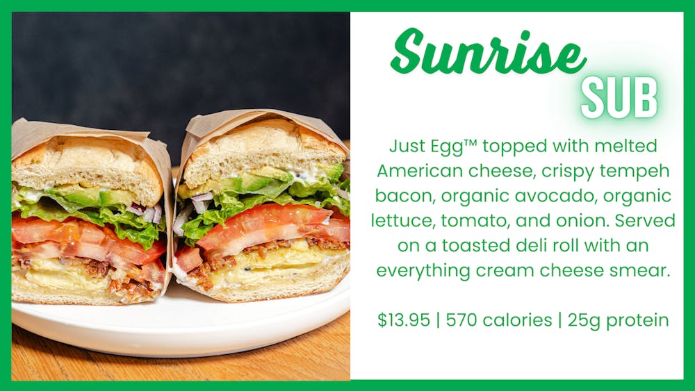 Sunrise Sub sandwich with Just Egg™, melted vegan American cheese, crispy tempeh bacon, organic avocado, lettuce, tomato, and onion, served on a toasted deli roll with an everything cream cheese smear.