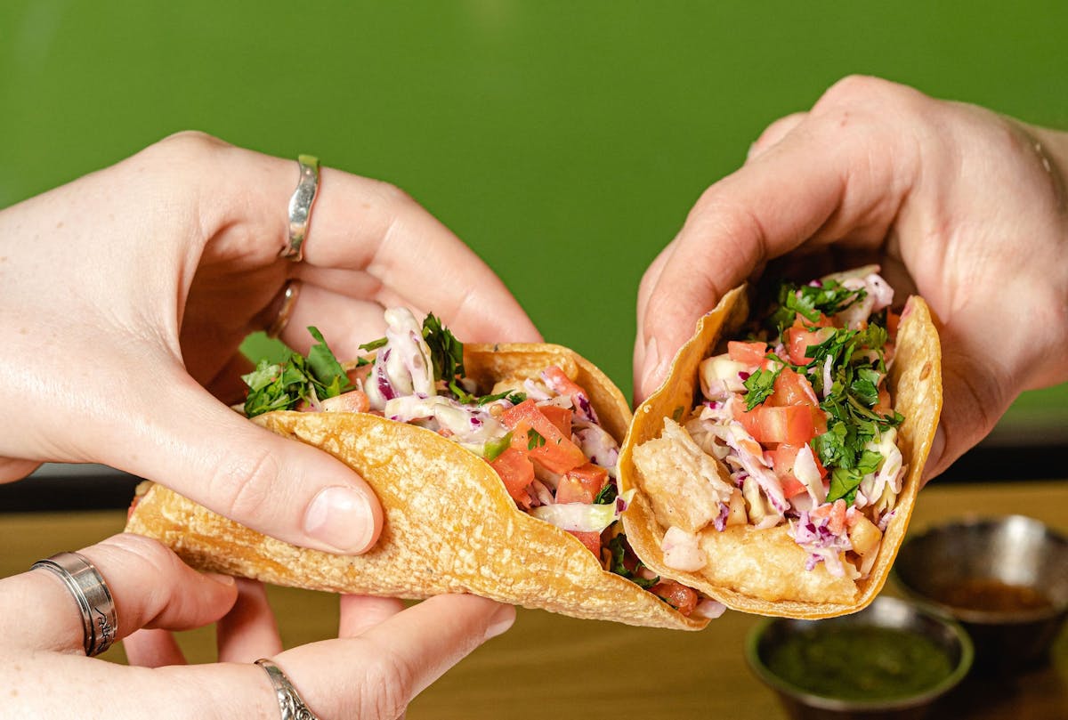 a hand holding a sandwich