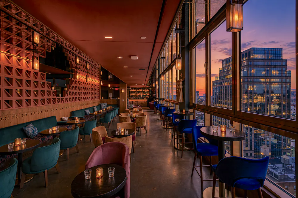 a room with tables and chairs and a view of a city
