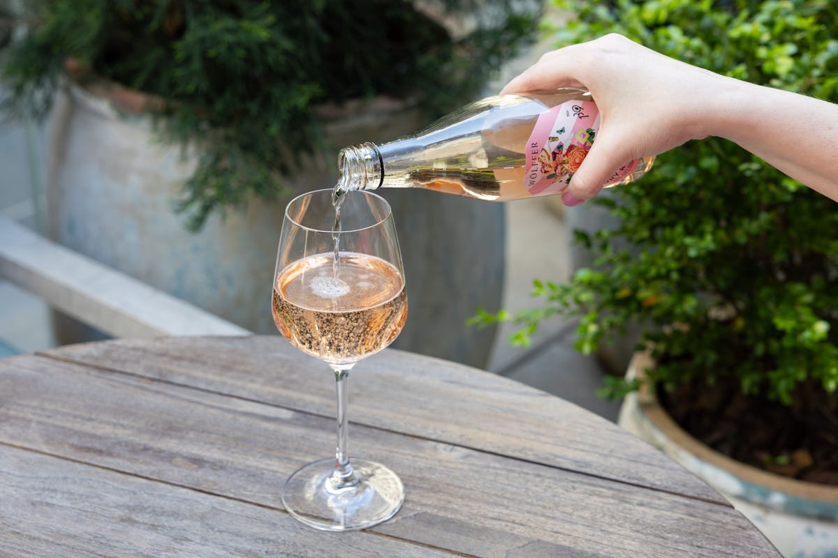 a hand holding a bottle of wine