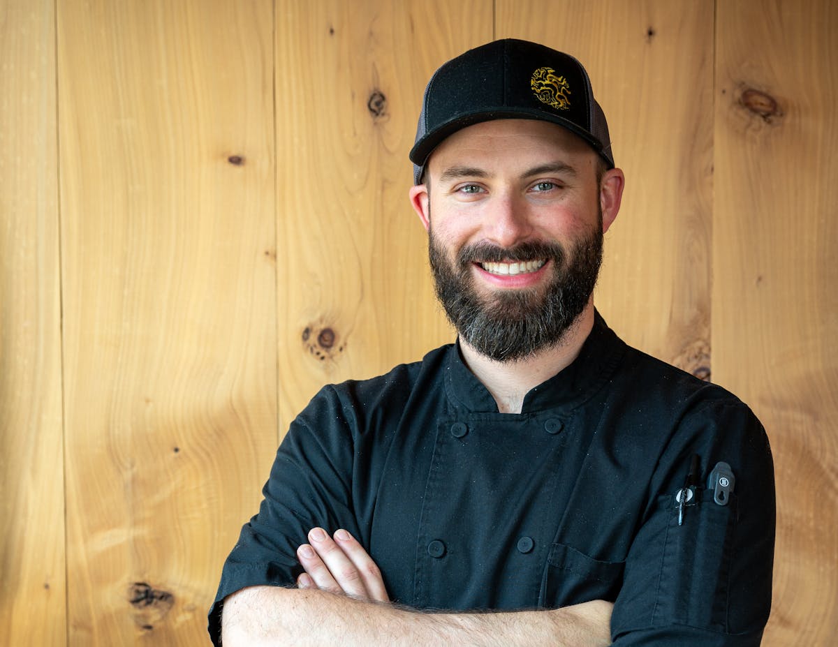 a man wearing a hat and smiling at the camera