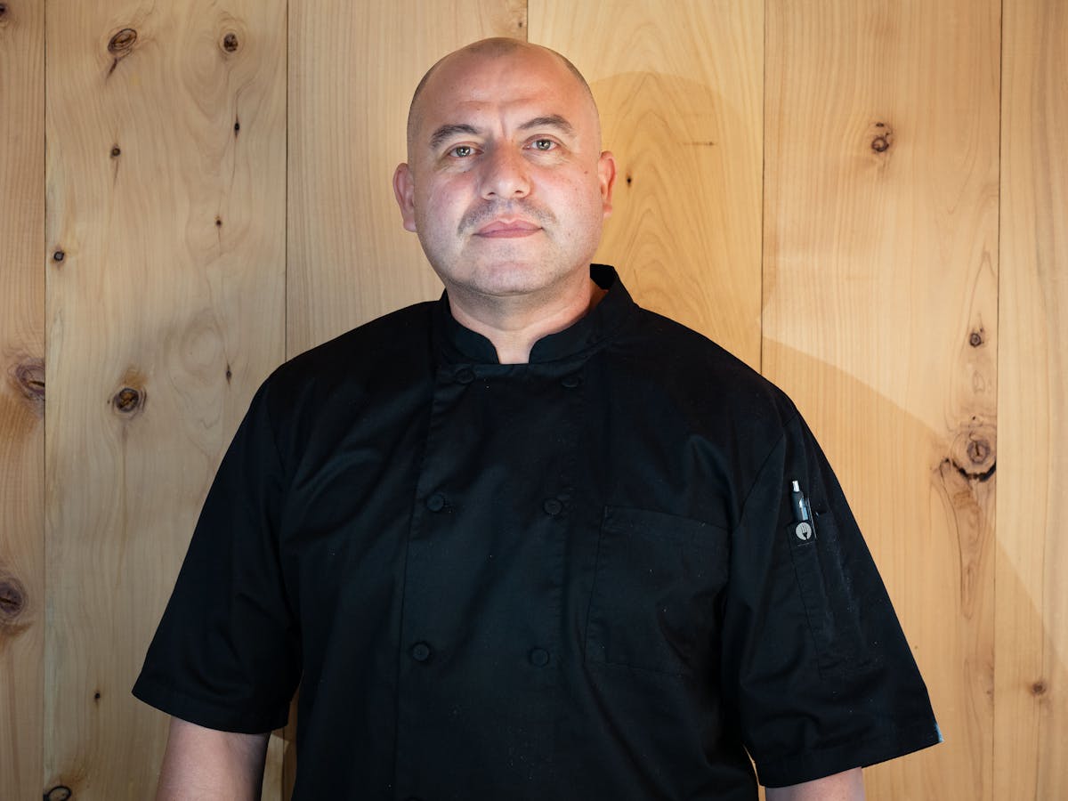 a man standing in front of a wood wall