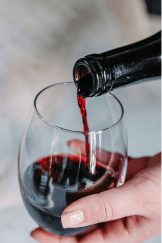 A person pouring wine in a glass