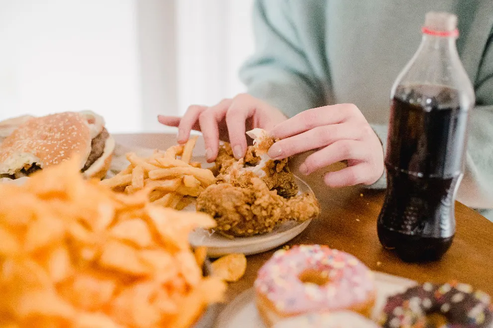 person tearing off fried chicken