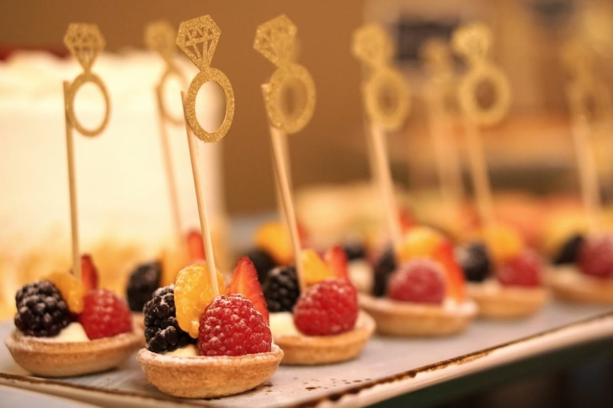 a close up of a cake with fruit on top of a table