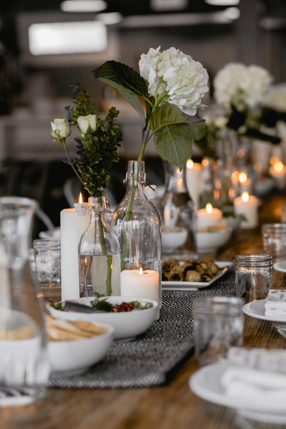 a vase of flowers on a table with wine glasses