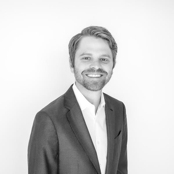 a man wearing a suit and smiling at the camera