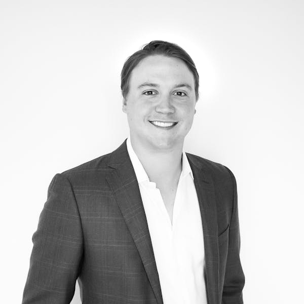 a man wearing a suit and smiling at the camera