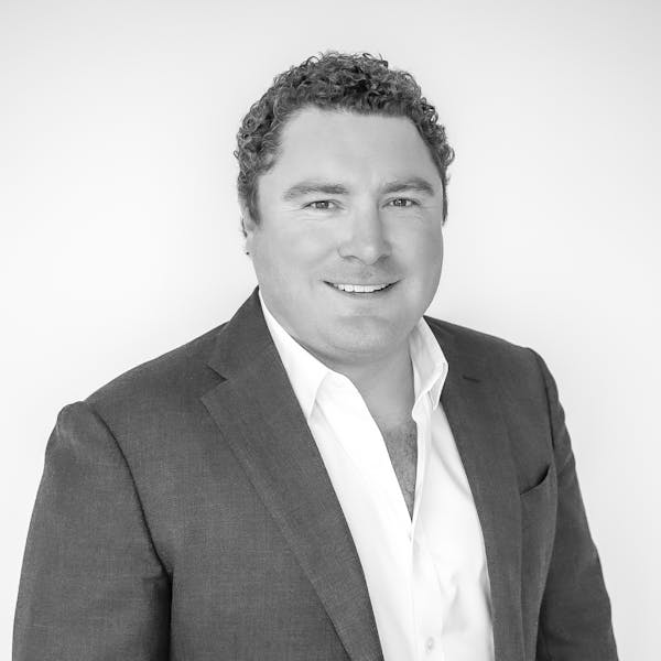 a man wearing a suit and smiling at the camera