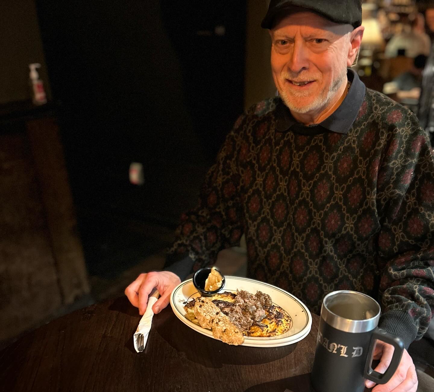 a man sitting at a table with a plate of food