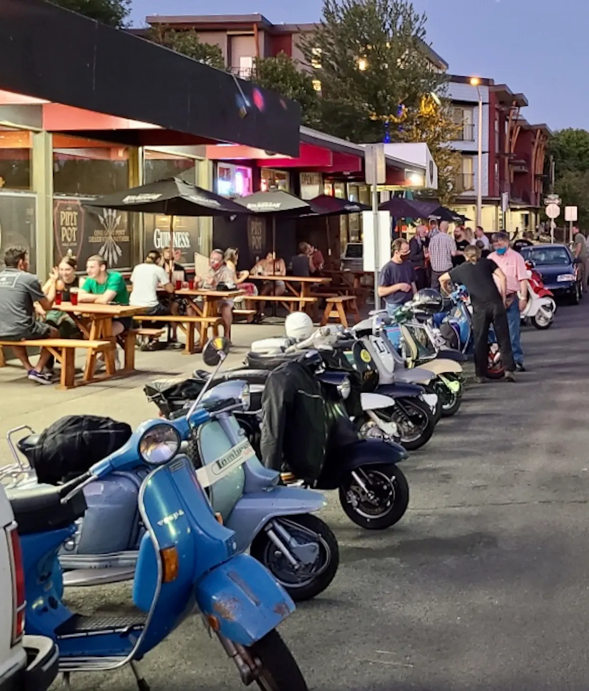 a row of parked motorcycles sitting on the side of a building