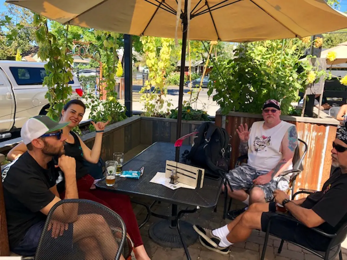 a group of people sitting at a table using a laptop