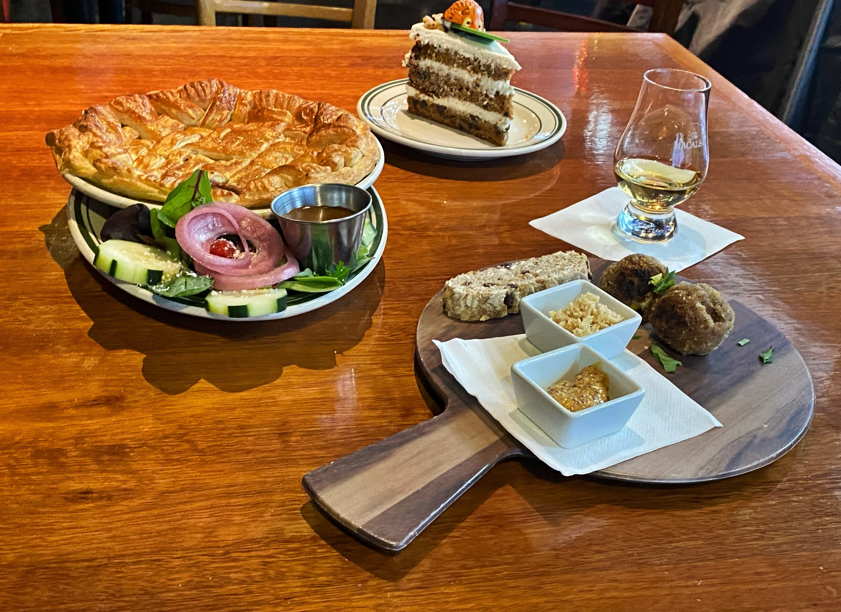 a wooden table topped with plates of food on a plate