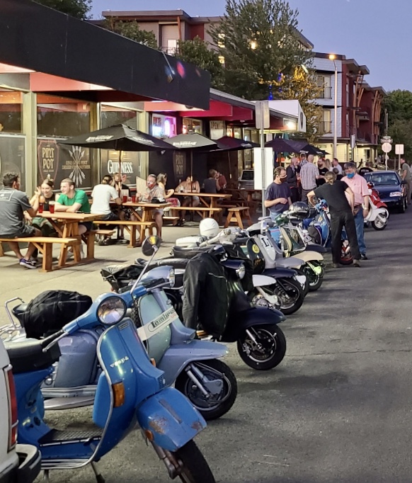a row of parked motorcycles sitting on the side of a building