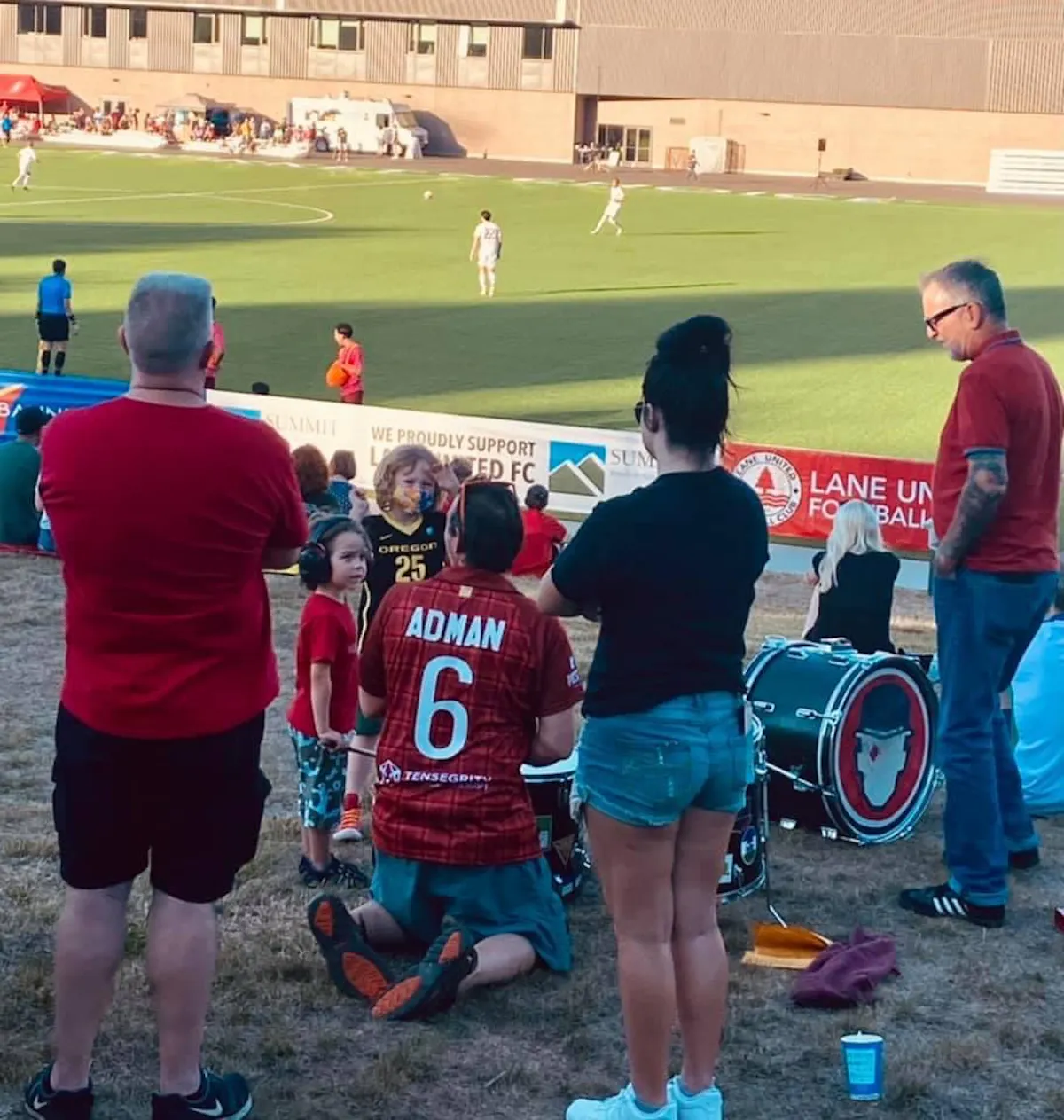 a group of people standing in front of a football field