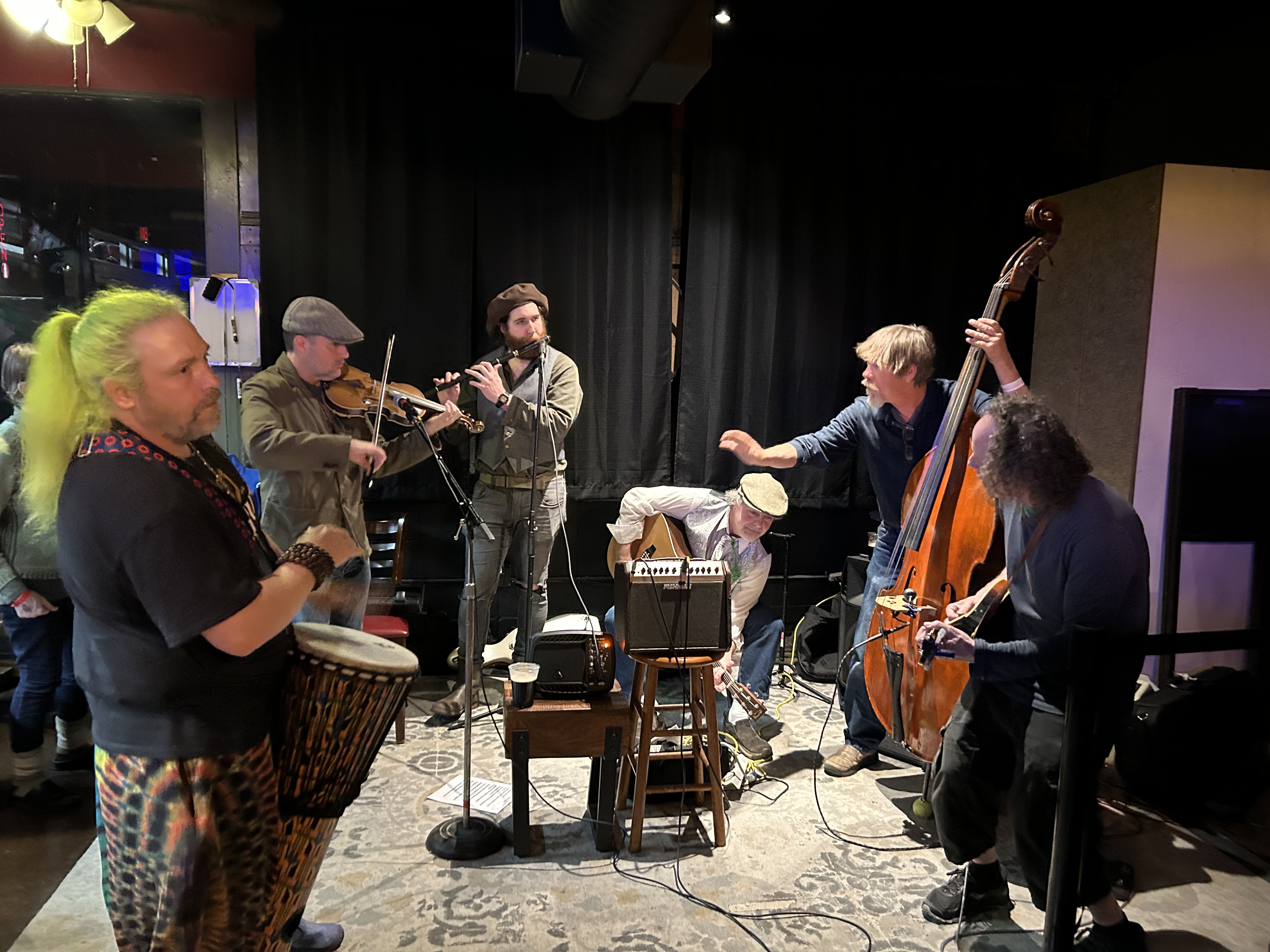 a group of people playing instruments and performing on a stage