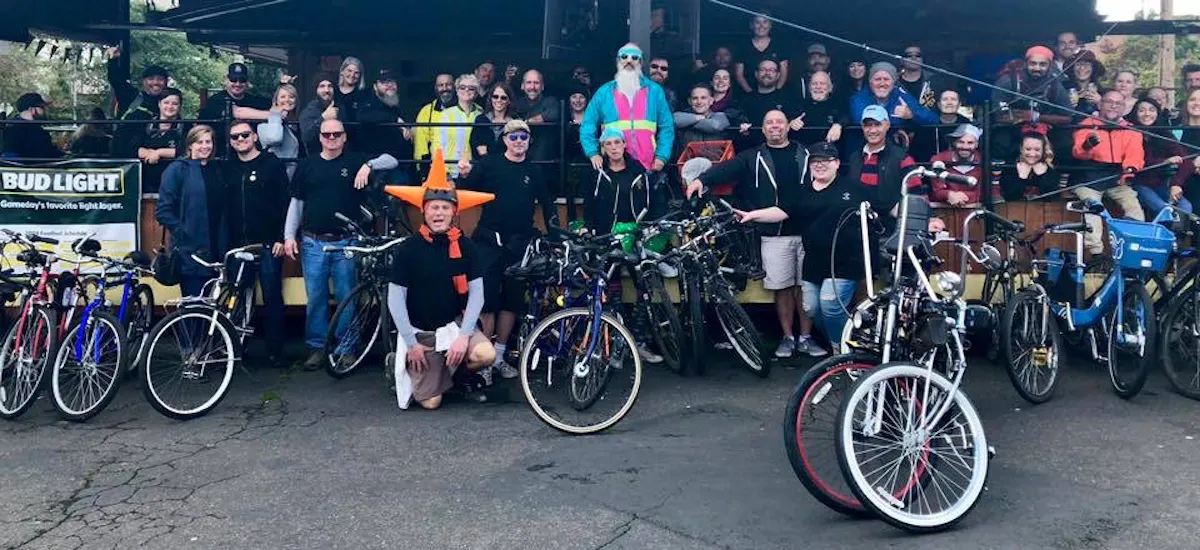a group of people riding on the back of a bicycle