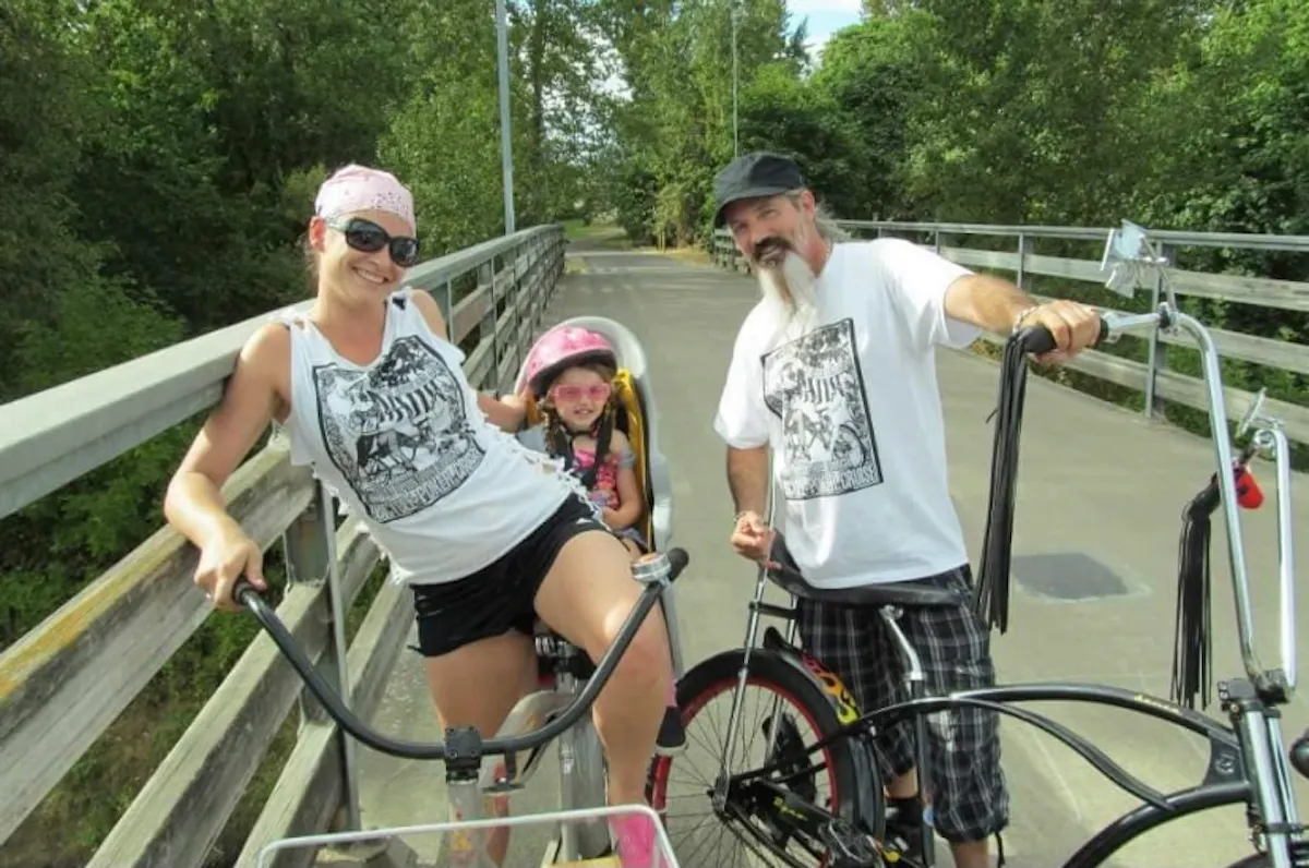 a group of people riding on the back of a bicycle