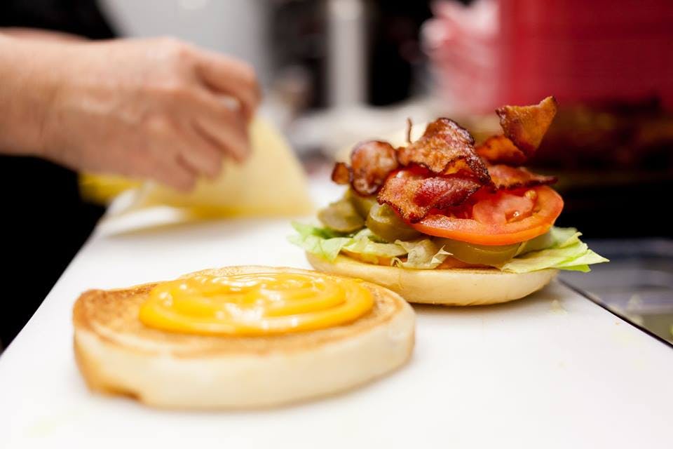 a person preparing a hamburger