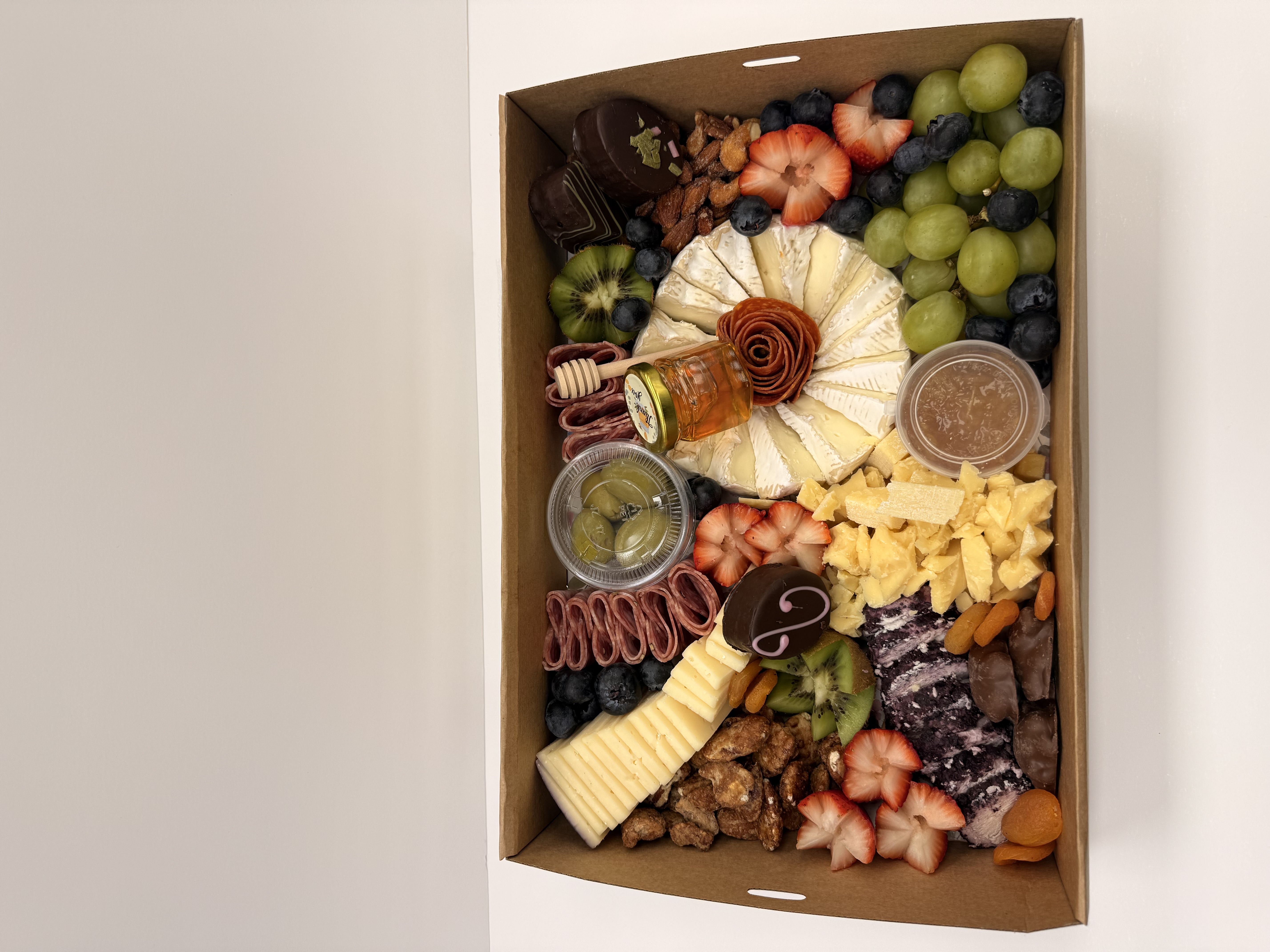 a box of food with different types of cheeses and fruits