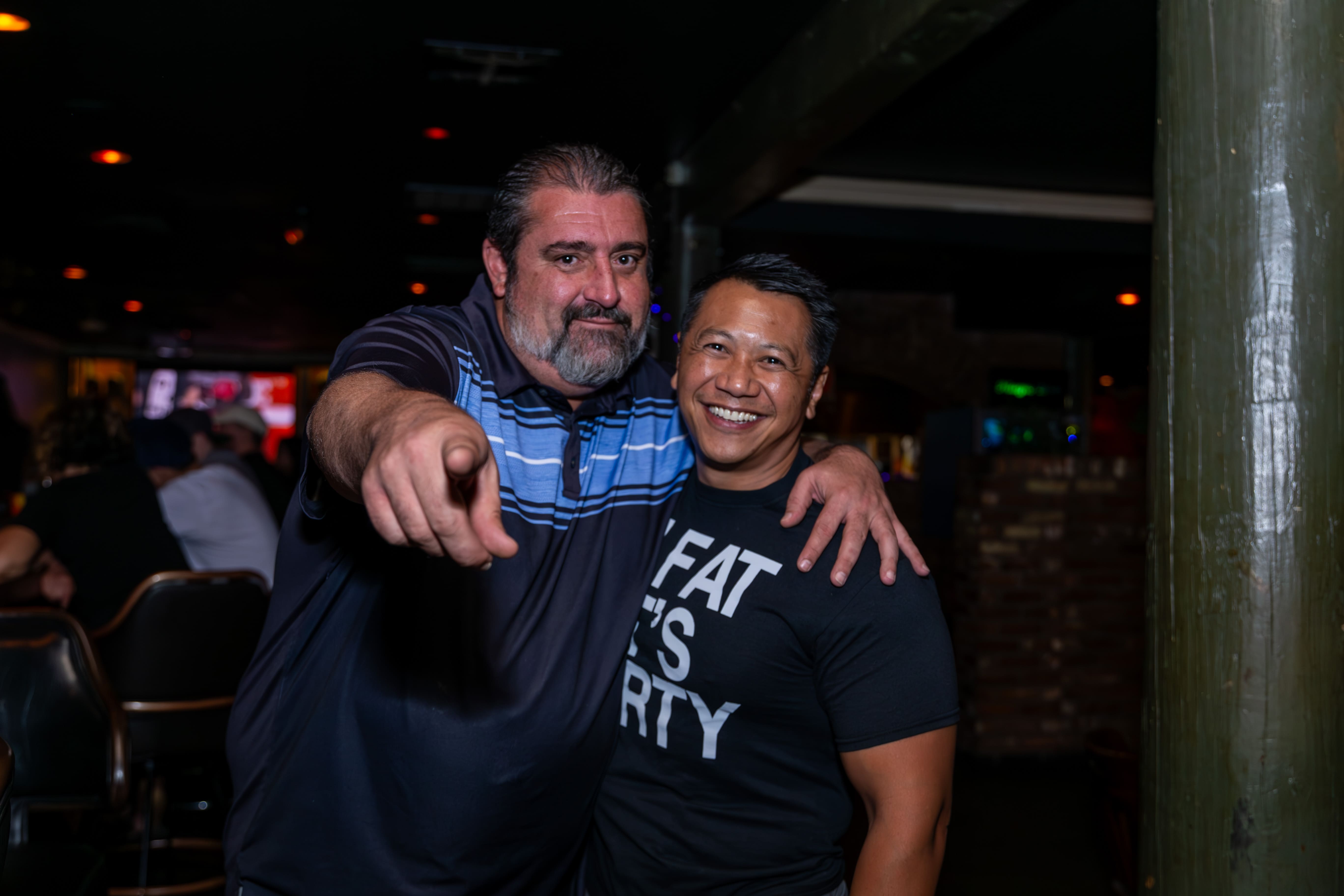 Two friends smiling during a night at Starboard Tack